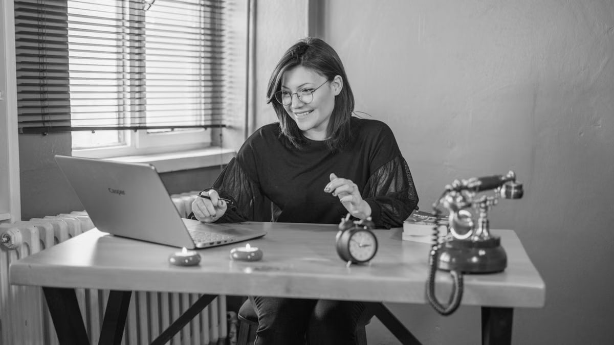A young woman working on her laptop in a vintage-style office setting.